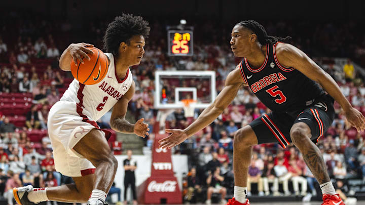 Feb 1, 2025; Tuscaloosa, Alabama, USA; Alabama Crimson Tide guard Aden Holloway (2) drives the ball against Georgia Bulldogs guard Silas Demary Jr. (5) during the second half at Coleman Coliseum. Mandatory Credit: Will McLelland-Imagn Images