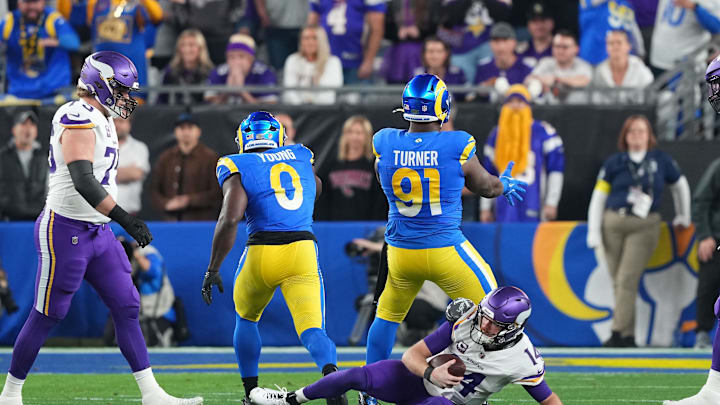 Jan 13, 2025; Glendale, AZ, USA; Los Angeles Rams defensive tackle Kobie Turner (91) reacts after making a sack on Minnesota Vikings quarterback Sam Darnold (14) during the first half in an NFC wild card game at State Farm Stadium. Mandatory Credit: Joe Camporeale-Imagn Images
