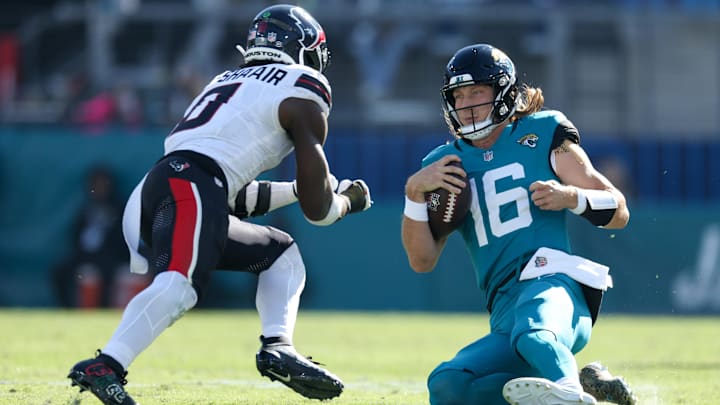 Dec 1, 2024; Jacksonville, Florida, USA; Jacksonville Jaguars quarterback Trevor Lawrence (16) slides down in front of Houston Texans linebacker Azeez Al-Shaair (0) in the second quarter in the second quarter at EverBank Stadium. Mandatory Credit: Nathan Ray Seebeck-Imagn Images