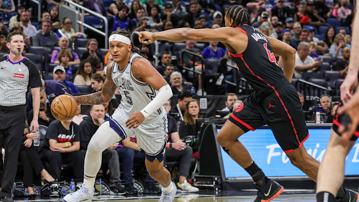 Orlando Magic forward Paolo Banchero (5) drives to the basket against Toronto Raptors forward Scottie Barnes (4) during the first quarter at Kia Center.