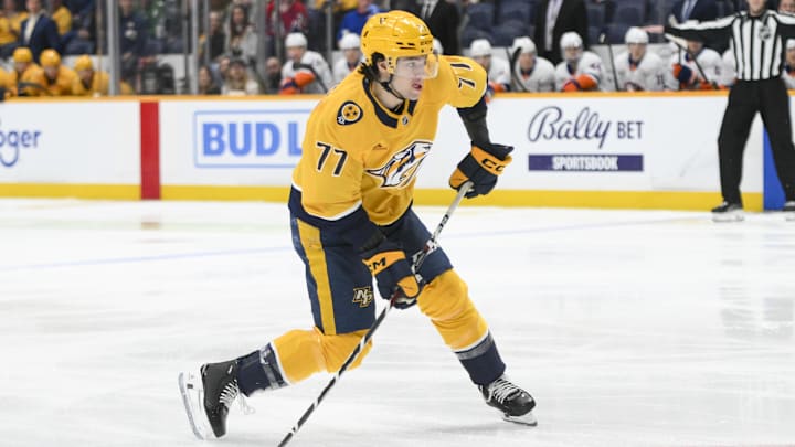 Apr 8, 2025; Nashville, Tennessee, USA;  Nashville Predators right wing Luke Evangelista (77) takes a shot on goal against the New York Islanders during the first period at Bridgestone Arena. Mandatory Credit: Steve Roberts-Imagn Images