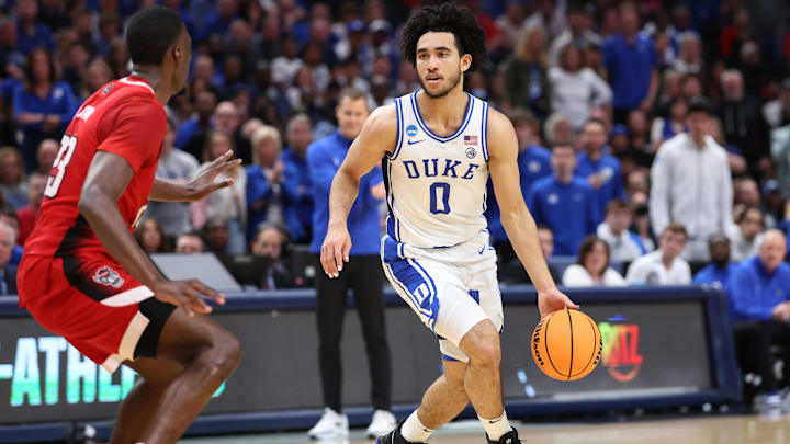 Mar 31, 2024; Dallas, TX, USA; Duke Blue Devils guard Jared McCain (0) controls the ball against North Carolina State Wolfpack forward Mohamed Diarra (23) in the first half in the finals of the South Regional of the 2024 NCAA Tournament at American Airline Center. Mandatory Credit: Kevin Jairaj-Imagn Images