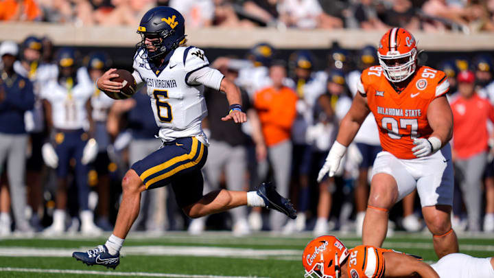 West Virginia Mountaineers quarterback Garrett Greene (6) leaps past Oklahoma State Cowboys linebacker Gabe Brown (32) and nose tackle Justin Kirkland (97) on his way to the end zone to score a touchdown during a college football game between the Oklahoma State Cowboys (OSU) and the West Virginia Mountaineers at Boone Pickens Stadium in Stillwater, Okla., Saturday, Oct. 5, 2024.