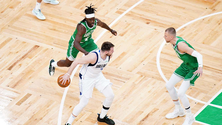 Jun 17, 2024; Boston, Massachusetts, USA: Dallas Mavericks guard Luka Doncic (77) controls the ball against Boston Celtics guard Jrue Holiday (4) and center Kristaps Porzingis (8) in the first quarter during game five of the 2024 NBA Finals at TD Garden. Mandatory Credit: David Butler II-Imagn Images Jun 17, 2024; Boston, Massachusetts, USA: Dallas Mavericks guard Luka Doncic (77) controls the ball against Boston Celtics guard Jrue Holiday (4) and center Kristaps Porzingis (8) in the first quarter during game five of the 2024 NBA Finals at TD Garden. Mandatory Credit: David Butler II-Imagn Images