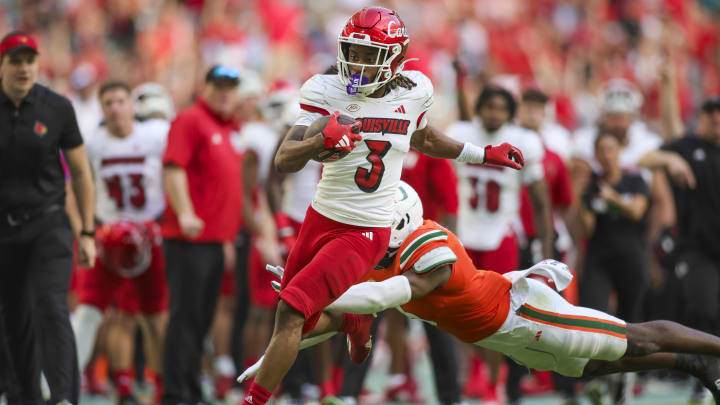 Nov 18, 2023; Miami Gardens, Florida, USA; Louisville Cardinals wide receiver Kevin Coleman (3) runs with the football for a touchdown ahead of Miami Hurricanes safety Kamren Kinchens (5) during the fourth quarter at Hard Rock Stadium. Mandatory Credit: Sam Navarro-USA TODAY Sports Nov 18, 2023; Miami Gardens, Florida, USA; Louisville Cardinals wide receiver Kevin Coleman (3) runs with the football for a touchdown ahead of Miami Hurricanes safety Kamren Kinchens (5) during the fourth quarter at Hard Rock Stadium. Mandatory Credit: Sam Navarro-USA TODAY Sports