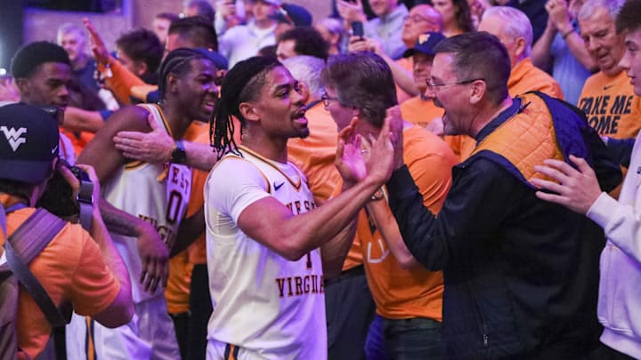 Feb 28, 2026; Morgantown, West Virginia, USA; West Virginia Mountaineers guard Jasper Floyd (1) celebrates with fans after defeating the BYU Cougars at Hope Coliseum. Mandatory Credit: Ben Queen-Imagn Images