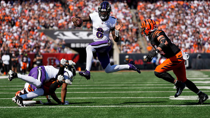 Baltimore Ravens quarterback Lamar Jackson (8) leaps away from Cincinnati Bengals defensive end Sam Hubbard (94) on a keeper in the first quarter of the NFL Week 5 game between the Cincinnati Bengals and Baltimore Ravens at Paycor Stadium in downtown Cincinnati on Sunday, Oct. 6, 2024. The Bengals led 17-14 at halftime.