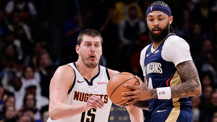Nov 6, 2023; Denver, Colorado, USA; Denver Nuggets center Nikola Jokic (15) looks to steal the ball from New Orleans Pelicans forward Brandon Ingram (14) in the fourth quarter at Ball Arena. Mandatory Credit: Isaiah J. Downing-Imagn Images