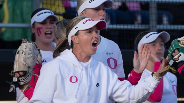 Oregon coach Melyssa Lombardi, center, cheers her team during the first inning against Michigan at Jane Sanders Stadium.
