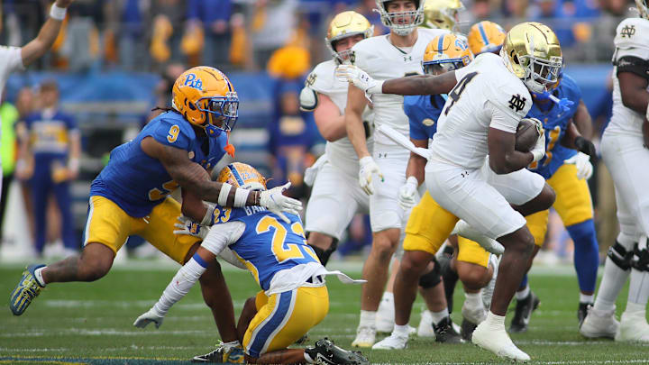 Notre Dame Fighting Irish running back Jeremiyah Love (4) trips up Pittsburgh Panthers defensive back Kavir Bains (23) causing him to collide with linebacker Kyle Louis (9) while rushing downfield during the first half at Acrisure Stadium in Pittsburgh, PA on November 15, 2025. Notre Dame Fighting Irish running back Jeremiyah Love (4) trips up Pittsburgh Panthers defensive back Kavir Bains (23) causing him to collide with linebacker Kyle Louis (9) while rushing downfield during the first half at Acrisure Stadium in Pittsburgh, PA on November 15, 2025.