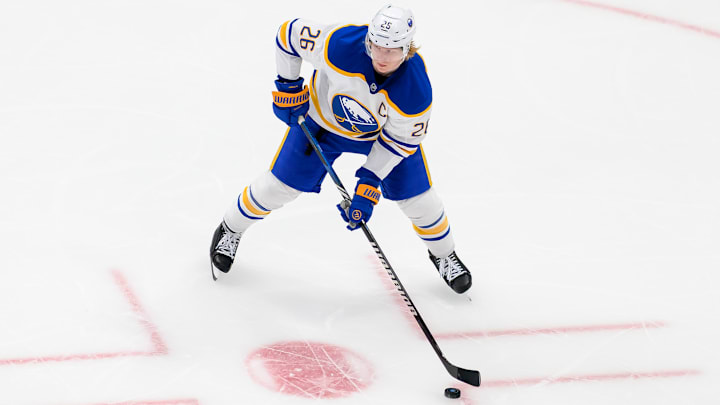 Rasmus Dahlin (26) looking to make a quick pass in a game against the Utah Hockey Club. 