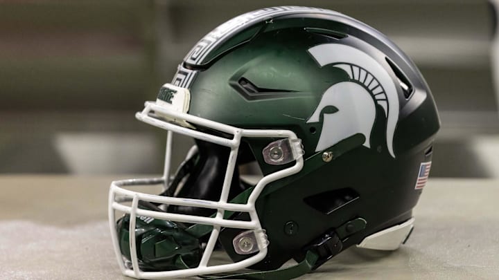 Nov 24, 2023; Detroit, Michigan, USA; A Michigan State Spartans helmet sits on a bench during the second half game against the Penn State Nittany Lions at Ford Field. Mandatory Credit: David Reginek-Imagn Images Nov 24, 2023; Detroit, Michigan, USA; A Michigan State Spartans helmet sits on a bench during the second half game against the Penn State Nittany Lions at Ford Field. Mandatory Credit: David Reginek-Imagn Images