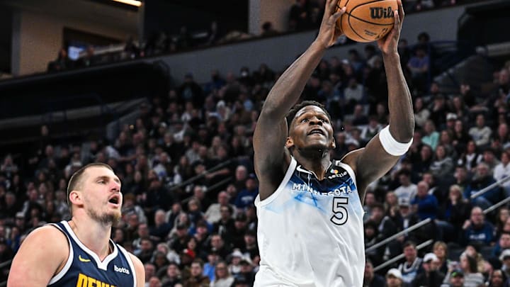 Jan 25, 2025; Minneapolis, Minnesota, USA; Minnesota Timberwolves guard Anthony Edwards (5) goes to the basket for a slam dunk over Denver Nuggets center Nikola Jokic (15) during the third quarter at Target Center. Mandatory Credit: Jeffrey Becker-Imagn Images