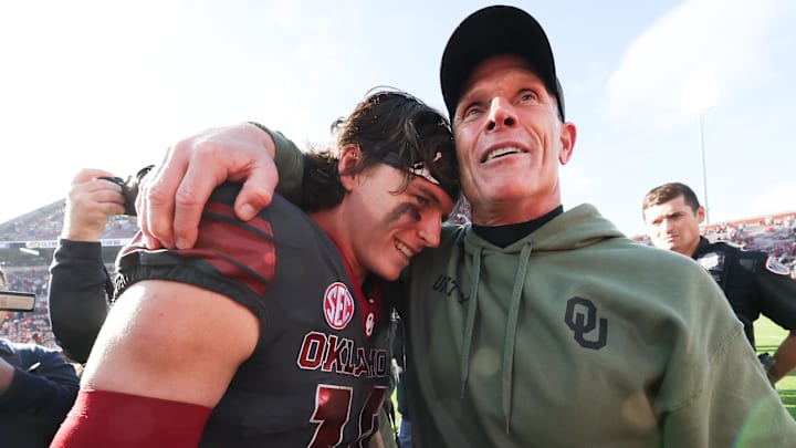 Oklahoma Sooners quarterback John Mateer (10) hugs Oklahoma Sooners head coach Brent Venables Oklahoma Sooners quarterback John Mateer (10) hugs Oklahoma Sooners head coach Brent Venables