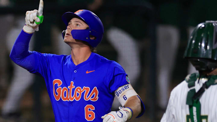 Florida utility Bobby Boser (6) points skyward after a three-run home run passing by Jacksonville catcher Nick DeLisi (38) during the fifth inning of an NCAA baseball matchup Monday, Feb. 17, 2025 at Jacksonville University in Jacksonville, Fla. Florida defeated Jacksonville 10-4. [Corey Perrine/Florida Times-Union]
