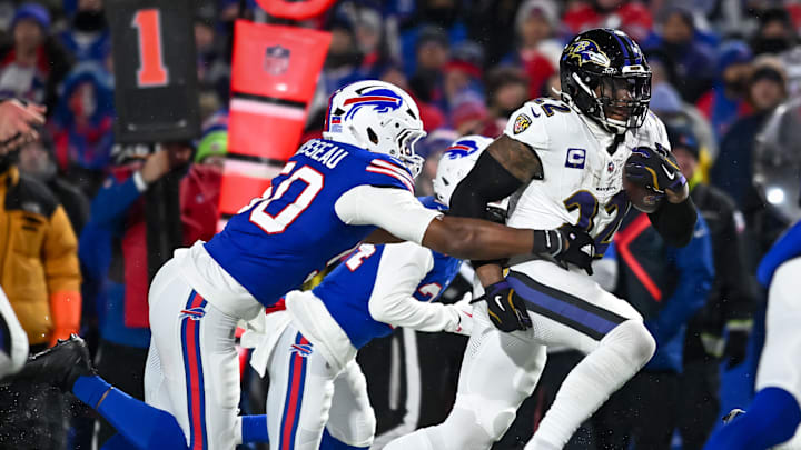 Jan 19, 2025; Orchard Park, New York, USA; Baltimore Ravens running back Derrick Henry (22) carries the ball as Buffalo Bills defensive end Greg Rousseau (50) attempts a tackle in the third quarter of a 2025 AFC divisional round game at Highmark Stadium. 