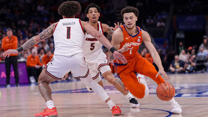 Mar 14, 2025; Charlotte, NC, USA; Clemson Tigers guard Chase Hunter (1) goes to the basket against Louisville Cardinals guard J'Vonne Hadley (1) during the first half at Spectrum Center. Mandatory Credit: Jim Dedmon-Imagn Images