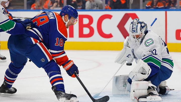 Sep 29, 2026; Edmonton, Alberta, CAN;  Vancouver Canucks goaltender Kevin Lankinen (32) makes a save on Edmonton Oilers forward Zach Hyman (18) during the first period at Rogers Place.  Mandatory Credit: Perry Nelson-Imagn Images