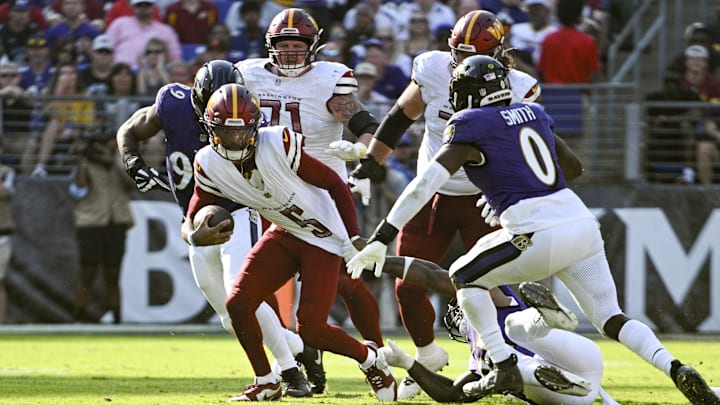 Baltimore Ravens defensive end Yannick Ngakoue (91) pulls down Washington Commanders quarterback Jayden Daniels (5) by his jersey for a sack during the second half at M&T Bank Stadium.