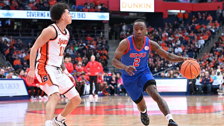 Feb 14, 2026; Syracuse, New York, USA; Southern Methodist University Mustangs guard Boopie Miller (2) drives to the basket with Syracuse Orange guard Naithan George (11) defending in the first half at the JMA Wireless Dome. Mandatory Credit: Mark Konezny-Imagn Images