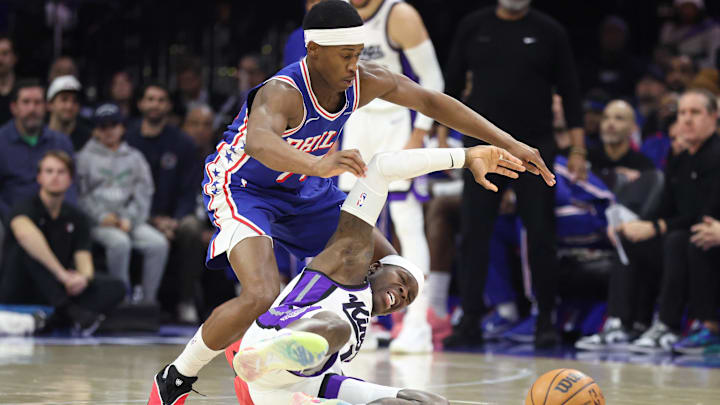 Jan 29, 2026; Philadelphia, Pennsylvania, USA; Philadelphia 76ers guard Vj Edgecombe (77) chases a loose ball past Sacramento Kings guard Dennis Schroder (17) during the fourth quarter at Xfinity Mobile Arena. Mandatory Credit: Bill Streicher-Imagn Images