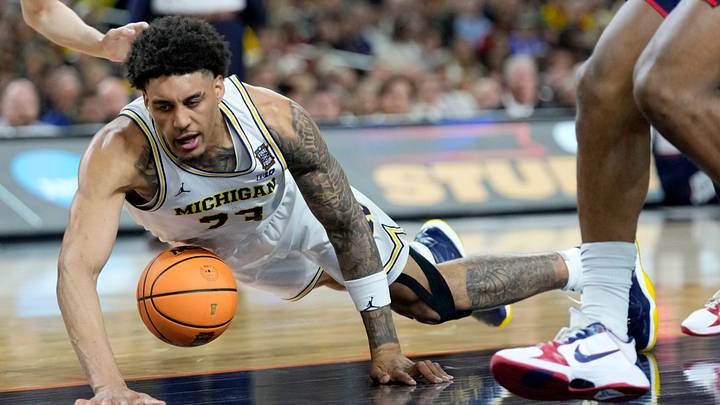 Michigan Wolverines forward Yaxel Lendeborg (23) dives for a loose ball Monday, April 6, 2026, during the NCAA men's basketball tournament national championship game against the UConn Huskies at Lucas Oil Stadium in Indianapolis.