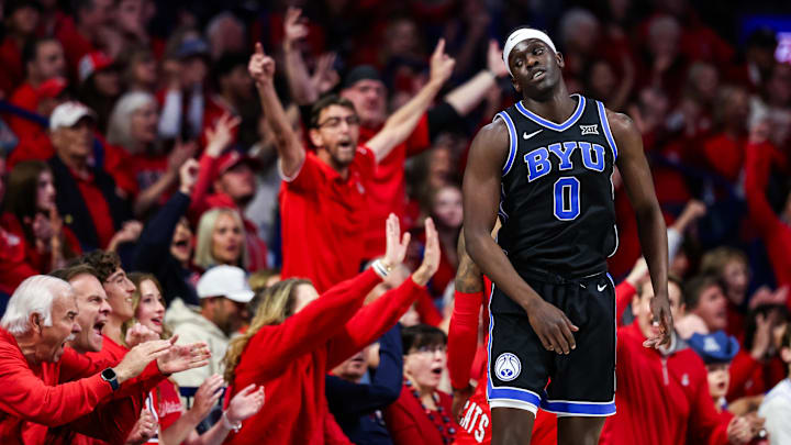 Feb 22, 2025; Tucson, Arizona, USA; BYU Cougars forward Mawot Mag (0) reacts after Arizona Wildcats guard Caleb Love (1) scores a three-point basket during the first half at McKale Center. Mandatory Credit: Aryanna Frank-Imagn Images