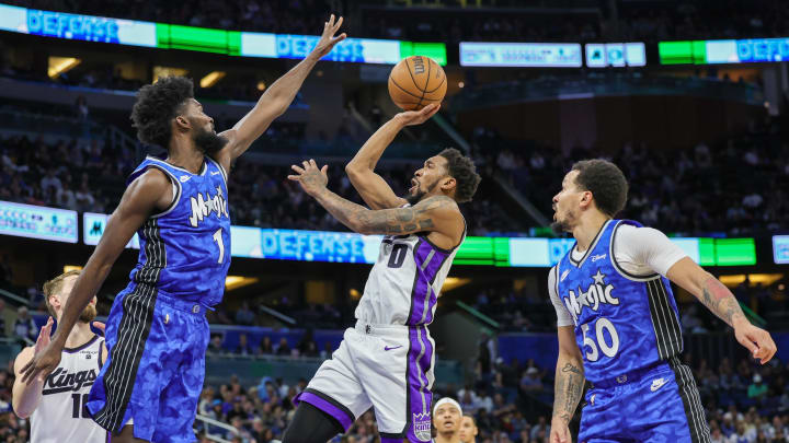 Mar 23, 2024; Orlando, Florida, USA; Sacramento Kings guard Malik Monk (0) shoots the ball against Orlando Magic forward Jonathan Isaac (1) during the second quarter at KIA Center. Mandatory Credit: Mike Watters-USA TODAY Sports