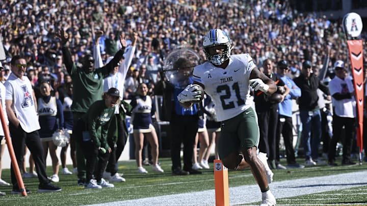 Nov 16, 2024; Annapolis, Maryland, USA; Tulane Green Wave running back Makhi Hughes (21) scores a touchdown during the first half against the Navy Midshipmen at Navy-Marine Corps Memorial Stadium. Mandatory Credit: Tommy Gilligan-Imagn Images Nov 16, 2024; Annapolis, Maryland, USA; Tulane Green Wave running back Makhi Hughes (21) scores a touchdown during the first half against the Navy Midshipmen at Navy-Marine Corps Memorial Stadium. Mandatory Credit: Tommy Gilligan-Imagn Images