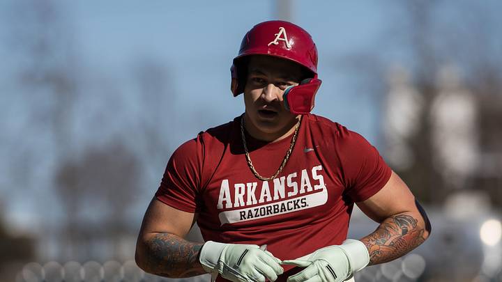 Arkansas outfielder Kuhio Aloy takes a glove off after reaching first base on a single during the third inning of the Razorbacks' scrimmage at Baum-Walker Stadium. 