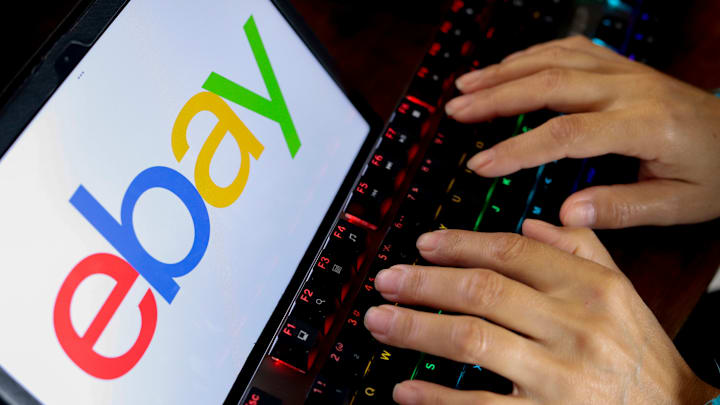 In this photo illustration, a person types next to the eBay...