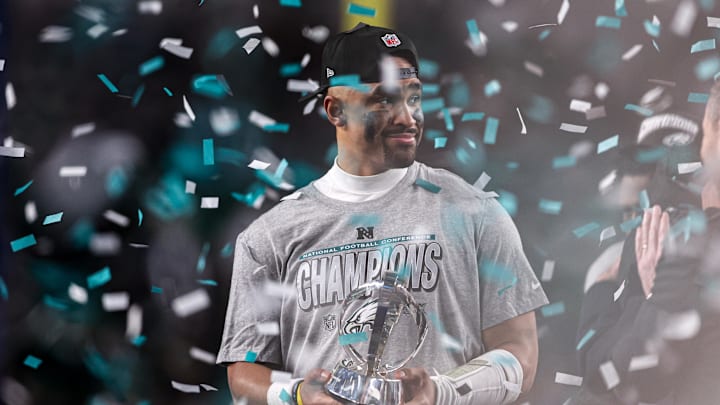 Jan 26, 2025; Philadelphia, PA, USA; Philadelphia Eagles quarterback Jalen Hurts (1) holds the NFC Championship trophy after a victory in the NFC Championship game against the Washington Commanders at Lincoln Financial Field. Mandatory Credit: Bill Streicher-Imagn Images Jan 26, 2025; Philadelphia, PA, USA; Philadelphia Eagles quarterback Jalen Hurts (1) holds the NFC Championship trophy after a victory in the NFC Championship game against the Washington Commanders at Lincoln Financial Field. Mandatory Credit: Bill Streicher-Imagn Images