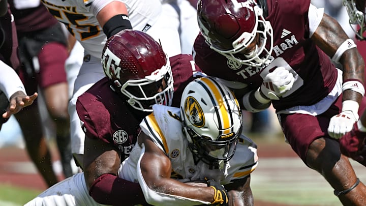 Oct 5, 2024; College Station, Texas, USA; Texas A&M Aggies defensive lineman Albert Regis (17) and linebacker Scooby Williams (0) stop Missouri Tigers running back Marcus Carroll (9) in the fourth quarter at Kyle Field. Mandatory Credit: Maria Lysaker-Imagn Images. 
