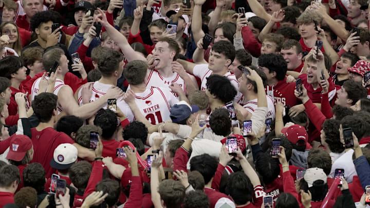 Wisconsin forward Austin Rapp (tongue wagging) and his teammates are swarmed by fans after their game Friday, February 13, 2026 at the Kohler Center in Madison, Wisconsin. Wisconsin beat 10th ranked Michigan State 92-71.