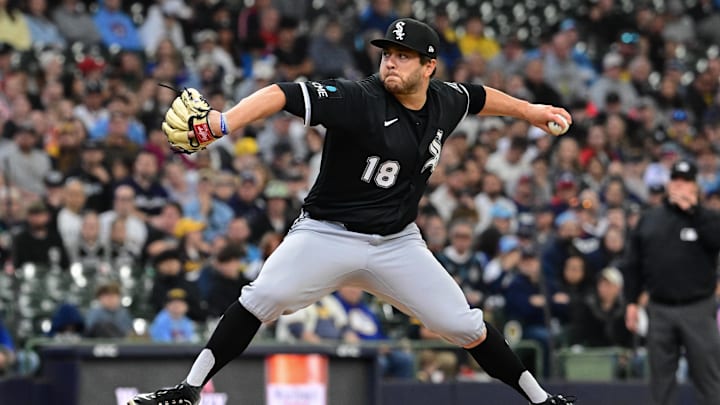 Anthony Kay throws a baseball in a black unifor