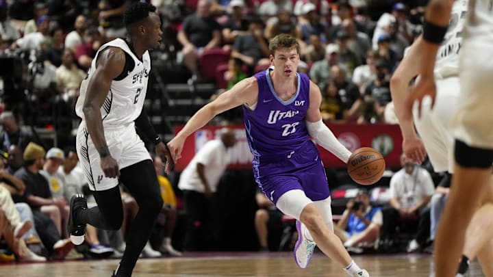 Jul 14, 2025; Las Vegas, NV, USA;  Utah Jazz forward Kyle Filipowski (22) dribbles the ball against San Antonio Spurs forward Osayi Osifo (26) during the first half of a NBA basketball game at Thomas & Mack Center. Mandatory Credit: Lucas Peltier-Imagn Images