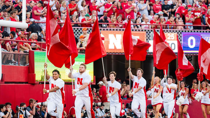 Sep 14, 2024; Lincoln, Nebraska, USA; Nebraska Cornhuskers cheerleaders carry flags across the field after a touchdown against the Northern Iowa Panthers during the first quarter at Memorial Stadium. Mandatory Credit: Dylan Widger-Imagn Images Sep 14, 2024; Lincoln, Nebraska, USA; Nebraska Cornhuskers cheerleaders carry flags across the field after a touchdown against the Northern Iowa Panthers during the first quarter at Memorial Stadium. Mandatory Credit: Dylan Widger-Imagn Images
