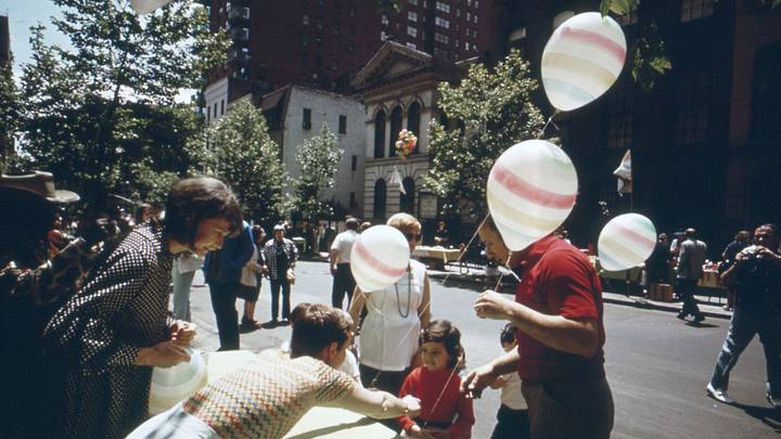 A festive neighborhood block party brings a celebratory summer energy to a Manhattan street, ca. 1973.