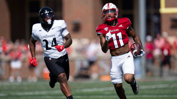 Miami Redhawks wide receiver Javon Tracy (11) runs downfield as Cincinnati Bearcats defensive end Darian Varner (24) defends in the first quarter of the College Football game at Yager Stadium in Cincinnati on Saturday, Sept. 14, 2024. Miami Redhawks wide receiver Javon Tracy (11) runs downfield as Cincinnati Bearcats defensive end Darian Varner (24) defends in the first quarter of the College Football game at Yager Stadium in Cincinnati on Saturday, Sept. 14, 2024.