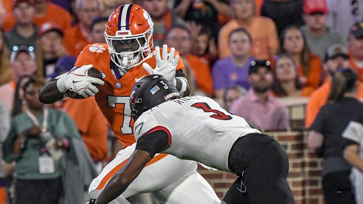 Nov 2, 2024; Clemson, South Carolina, USA; Clemson Tigers running back Phil Mafah (7) runs against Louisville Cardinals defensive back Quincy Riley (3) during the first quarter at Memorial Stadium. 
