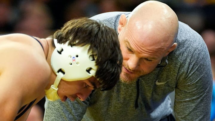 Penn State wrestling coach Cael Sanderson talks to Nittany Lions wrestler PJ Duke during a match against the Iowa Hawkeyes at Carver-Hawkeye Arena. 
