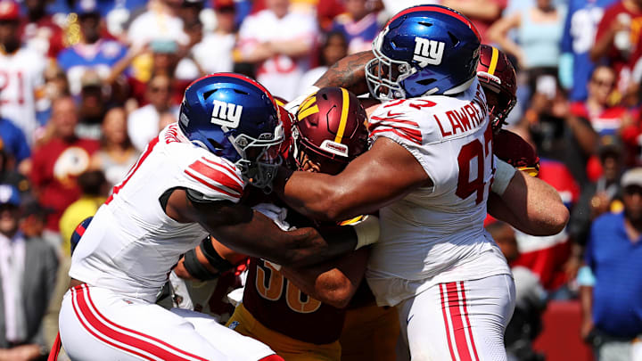 Sep 15, 2024; Landover, Maryland, USA; Washington Commanders running back Austin Ekeler (30) is tackled by New York Giants defensive tackle Dexter Lawrence II (97) during the fourth quarter.