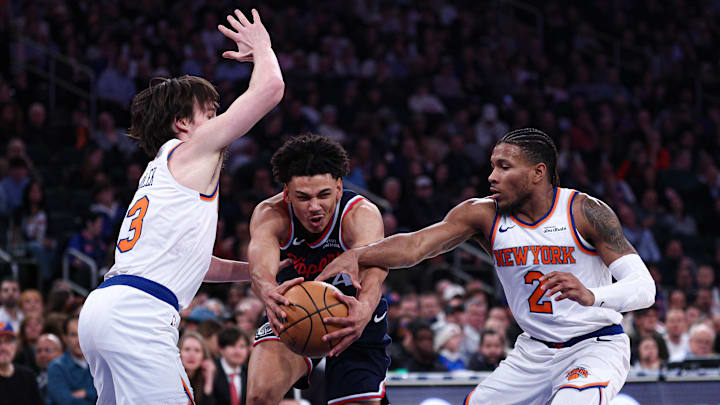 Jan 7, 2026; New York, New York, USA; LA Clippers guard Kobe Sanders (4) goes to the basket against New York Knicks guard Miles McBride (2) and guard Josh Hart (3) during the first half at Madison Square Garden. Mandatory Credit: Vincent Carchietta-Imagn Images