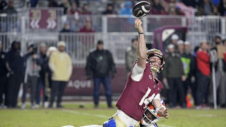 Nov 30, 2024; Tallahassee, Florida, USA; Florida State Seminoles quarterback Luke Kromenhoek (14) is pressured by Florida Gators linebacker Myles Graham (5) during the second half at Doak S. Campbell Stadium. Mandatory Credit: Melina Myers-Imagn Images
