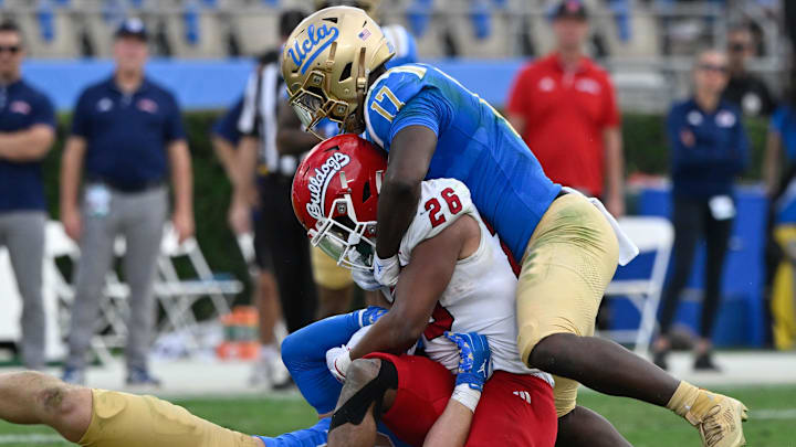 Nov 30, 2024; Pasadena, California, USA; UCLA Bruins linebackers Carson Schwesinger (49) and Jalen Woods (17) tackle Fresno State Bulldogs running back Bryson Donelson (26) during the third quarter at Rose Bowl. Mandatory Credit: Robert Hanashiro-Imagn Images Nov 30, 2024; Pasadena, California, USA; UCLA Bruins linebackers Carson Schwesinger (49) and Jalen Woods (17) tackle Fresno State Bulldogs running back Bryson Donelson (26) during the third quarter at Rose Bowl. Mandatory Credit: Robert Hanashiro-Imagn Images