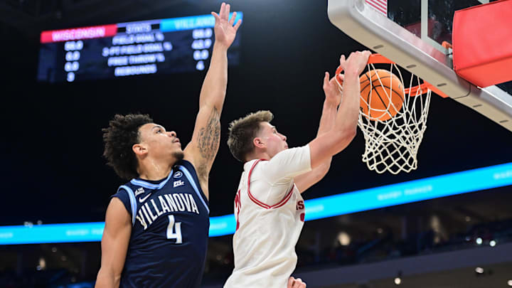 Dec 19, 2025; Milwaukee, Wisconsin, USA; Wisconsin Badgers forward Nolan Winter (31) dunks a basket against Villanova Wildcats guard Tyler Perkins (4) first half at the Fiserv Forum.