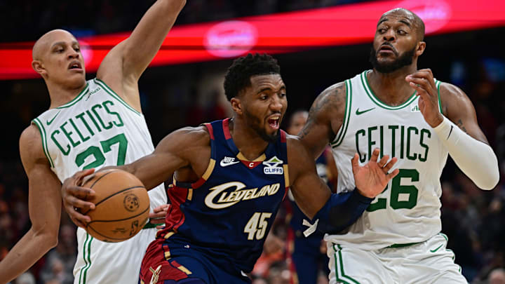 Nov 30, 2025; Cleveland, Ohio, USA; Cleveland Cavaliers guard Donovan Mitchell (45) drives on Boston Celtics forward Xavier Tillman (26) and guard Jordan Walsh (27) during the second half at Rocket Arena. Mandatory Credit: David Dermer-Imagn Images