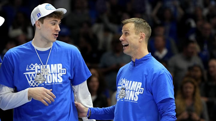 Duke Blue Devils forward Flagg and head coach Scheyer celebrate after winning the 2025 ACC Conference Championship game against the Louisville Cardinals at Spectrum Center. 