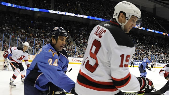 Apr 6, 2010; Atlanta, GA, USA; Atlanta Thrashers defenseman Chris Chelios (24) and center Rich Peverley (47) fight for the puck in the corner with New Jersey Devils center Travis Zajac (19) and left wing Zach Parise (9) in the first period at Philips Arena. The Devils defeated the Thrashers 3-0. Mandatory Credit: Dale Zanine-Imagn Images