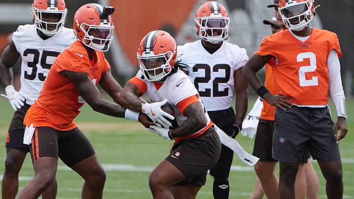 Browns quarterback Deshaun Watson hands off to running back Quinshon Judkins as teammates Dylan Sampson (22) and Shedeur Sanders (2) watch on the first day of minicamp in Berea, June 9, 2026. Browns quarterback Deshaun Watson hands off to running back Quinshon Judkins as teammates Dylan Sampson (22) and Shedeur Sanders (2) watch on the first day of minicamp in Berea, June 9, 2026.